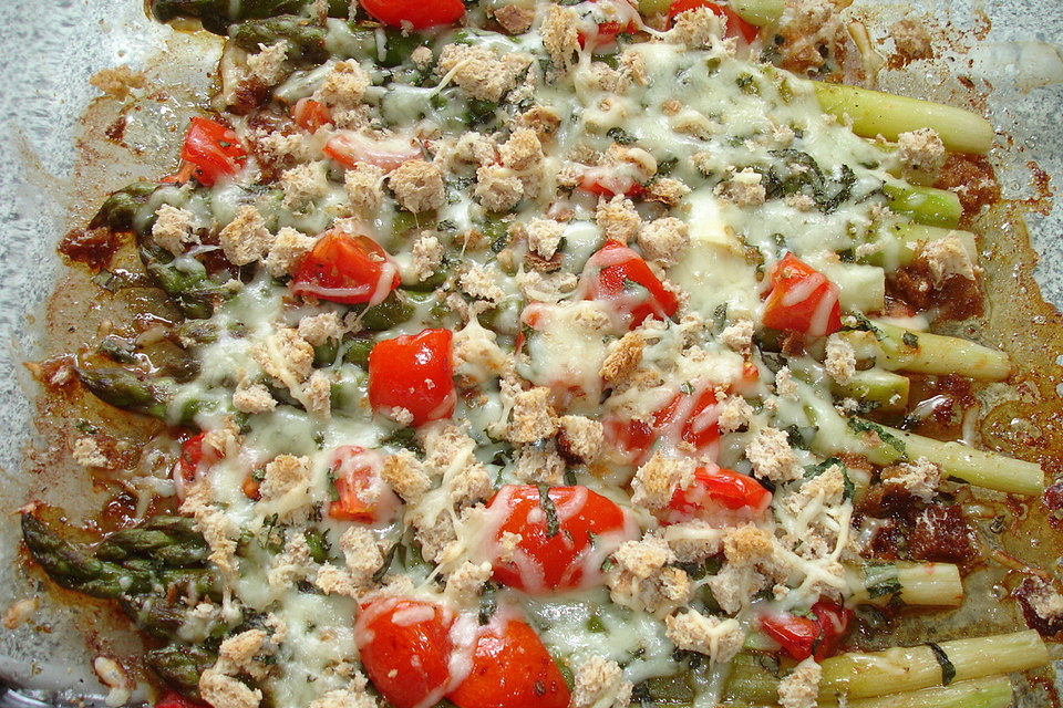 Grüner Spargel mit Tomaten mit Brot und Käse überbacken